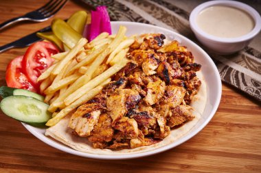 Arap tavuğu Shawarma Tabağı ve patates kızartması. Orta doğu yemekleri masasının yanında izole bir şekilde servis ediliyor.