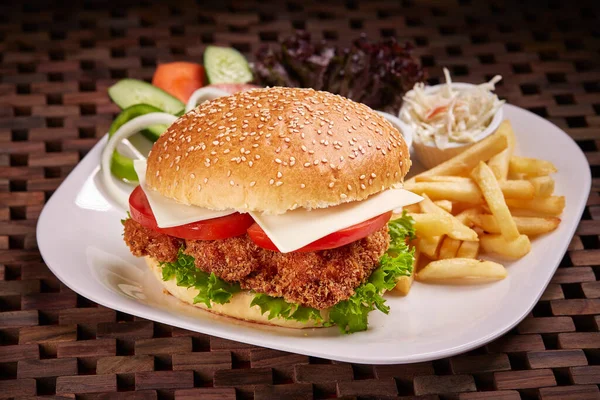 Chicken Fillet Sandwich or burger with fries and salad served in dish isolated on table side view of middle east food