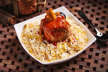 Arap Ghoozi kuzusu pirinçli biryani servis edilir. Masa başında izole edilmiş, orta doğu yemekleri.