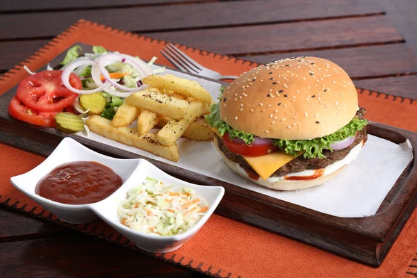 Grilled Angus Beef Burger with fries, salad and tomato sauce served in a dish isolated on table side view of middle east food