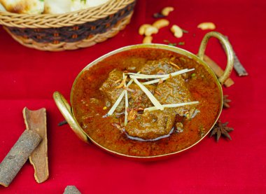 Karahi 'de servis edilen ekmekli Bhuna korma masala rogan gecekondu yemeği Hint, Pakistanlı ve Punjabi baharatlı yemeklerinin üst katında.