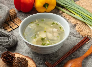 Yemek çubuklarıyla taze balık çorbası tenha bir masada servis edilir. Çin yemeklerinin üst görüntüsü.