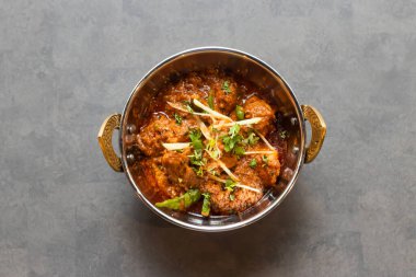 Karahi korma msala tabağında servis edilen tavuk Asya ve Hint yemekleri masasının üstünde.