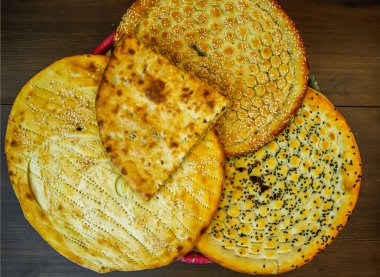 Ekmek çeşitleri Tandoori paratha, aloo naan, özel roghni, kalonji naan, Hindistan ve Pakistanlı yiyeceklerin üst görüntüsünde sepette servis edilir.
