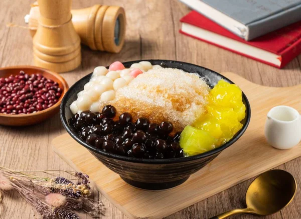 Shaved Ice with mango, red beans and rice ball served in bowl isolated on table top view of asian food