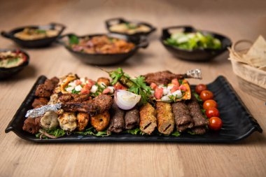 Tikka boti sefası kebap, tavuk, kuzu eti, kuzu eti ve sofrada servis edilen kuzu bbq tabağı ile karışık ızgara.