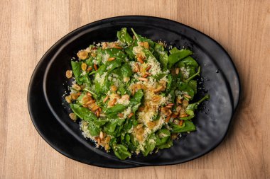 Kuskus 'la servis edilen roket yaprakları, Arap yemeklerinin üst görüntüsünde izole bir şekilde servis edilir.