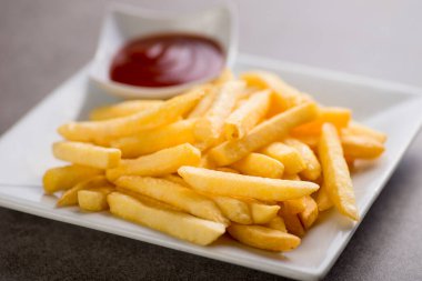 Patates kızartması ve domates sosu, gri arka planda, Arap yemeğinin üst görüntüsünde servis edilir.