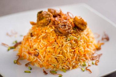 Karides biryani, gri arka planda, Arap yemeklerinin üst görüntüsünde servis edilir.