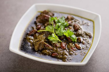Khoresh Sabzi, gri arka planda, Arap yemeklerinin üst görüntüsünde servis edilir.