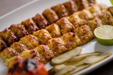 Limonlu Jujeh Kebab Kofta, gri arka planda, Arap yemeklerinin üst görüntüsünde servis edilir.