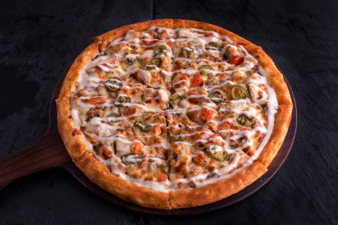 BBQ Tavuk Çiftliği pizzası kesme tahtasına izole edilmiş koyu arka planda İtalyan fast food 'u.