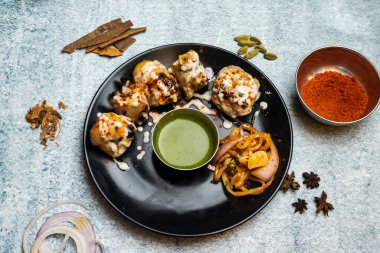 Baharatlı bbq Tavuğu Malai tikka boti kebabı biber soslu Gri arka planda izole edilmiş Bangladeş yemeklerinin üst görüntüsünde servis edilir