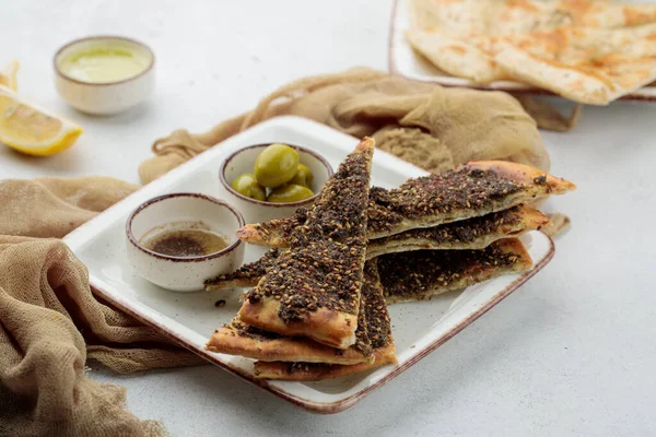 Manakish Zaatar peynirli pizza dilimi. Limonlu ve zeytinli. Masada servis edilmiş.