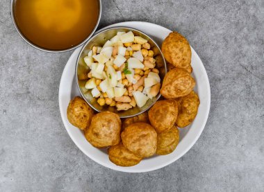 Safra, chnnay, baharatlı su, turşu ve Hint baharatlarının arka planına izole edilmiş soslu pani puri veya gol gappay.