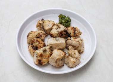 Tabakta servis edilen Malai tikka boti Hint ve Pakistanlı baharatlı yiyeceklerin en üstteki masasında izole.