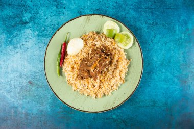 spicy beef pulao, polao, biryani, mandi, kacchi with egg and salad served in dish isolated on table top view of indian food