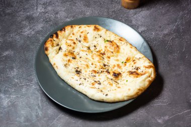 Butter naan or cheesy roti served in dish isolated on grey background top view of indian and bangladesh food