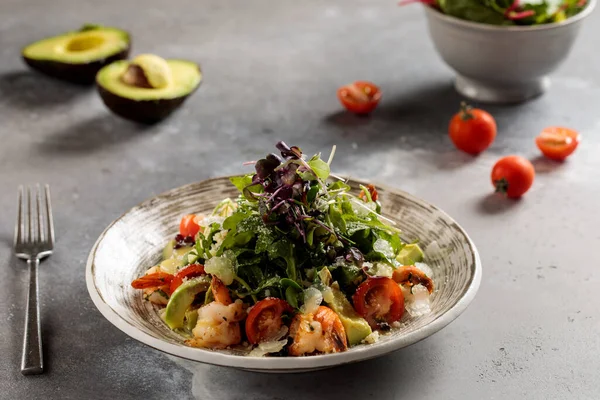 Sarımsaklı karides ve vişneli domates ve salatalıklı Avokado salatası, Arap kahvaltısının üst görüşünde servis edilen tabakta servis ediliyor.