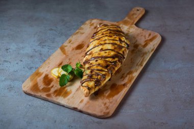 Nutella Çikolatalı Pizza, ahşap kesim tahtasının üzerinde servis edilen siyah biberli. Gri arka planda izole edilmiş fast food manzaralı.