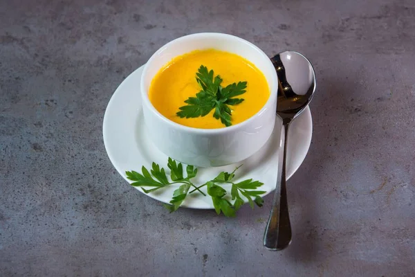 灰色の背景に隔離された皿にスプーンで提供されるカボチャのスープ鉄道食品のトップビュー — ストック写真