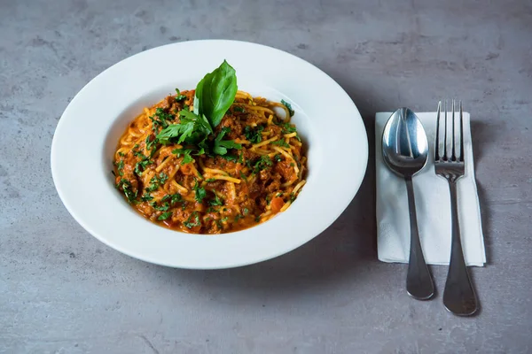 Bolonez Speghetti, gri arka planda, Bahreyn Gıda 'nın üst manzarasında servis edilir.