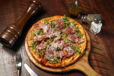 Parmesan pizzası kesme tahtasının üst görüntüsünde izole edilmiş İtalyan fast food masasında.