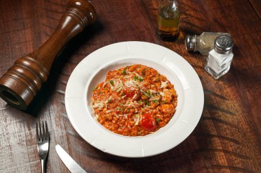 Domates soslu deniz mahsullü risotto ahşap masada servis edilir. İtalyan fast food 'unun üst manzarası.