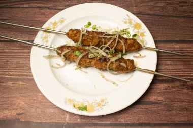 Seekh kebabı ya da Shikh kebabı tikka ahşap masa üzerinde servis edilir Hint baharatları