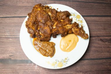 Tavuk pirzolası ya da mayonez soslu adam ahşap masa manzaralı Hint baharatlarıyla servis edilir.