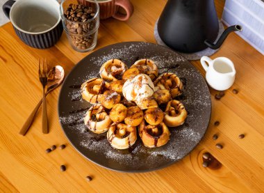 Kahve çekirdekleri, çatal, kaşık ile karamelize edilmiş muzlu waffle. Tahta masa üzerinde Tayvan yemeği manzarası.