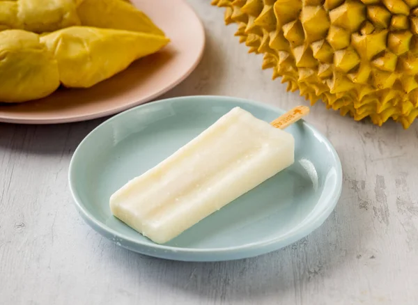 Super Thick Golden Pillow Durian Popsicle ice cream bar with raw fruits cut served in disposable glass isolated on background top view taiwan food