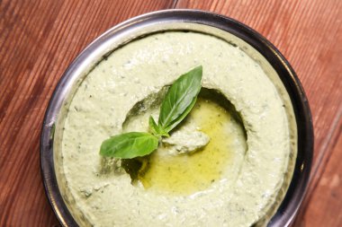 Pesto Humus, arka planda soğuk Arap yemeği mezzasının üstünde izole bir şekilde servis edilir.