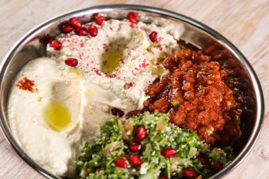 Baba Ganoujm, Türk Salsa, Labneh ve Taboula 'nın bulunduğu klasik mezza tabağı, Arap soğuk mezzasının arka planında yalıtılmış olarak servis ediliyor.
