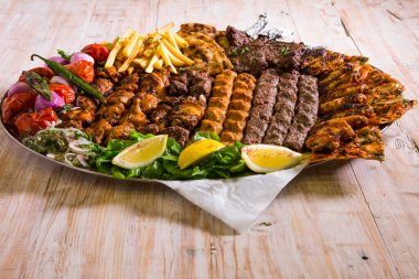 Tavuk tikka, sığır kebabı, koyun kebabı, kanat, boti, malai, pirzola, şiş tawook ile karışık ızgara.