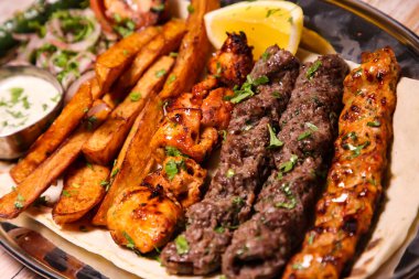 Tavuk tikka, sığır kebabı, koyun kebabı, kanat, boti, malai, şiş tawook ile karışık ızgaralar Arap yemeklerinin arka planında izole edilmiş olarak servis edilir.