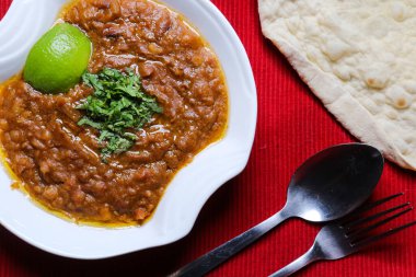 Kirli bezelye ezmesi, limon ve ekmek ile servis edilen fasulye, kırmızı hasırın üstünde, Arap mutfağında servis edilir.
