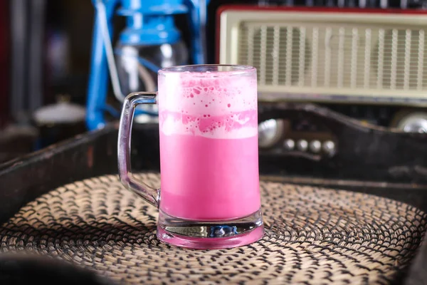 テーブルアラビア語の飲み物で赤いマットの上ビューに隔離されたマグカップで提供されるローズミルクシロップまたはグラブシェイク — ストック写真