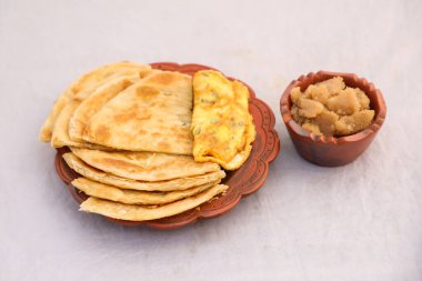 Desi kahvaltı omleti, halwa ve paratha arka planda tek başına bangladesi kahvaltısının üst görüntüsünde servis edilir.