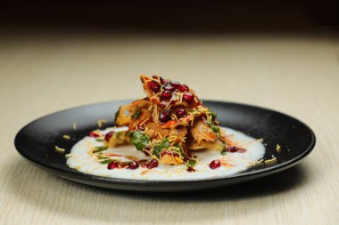 Doi Papri Chaat, papdi, bile bhalla, bhallay, patates, kraker, masala ve yoğurt arka planda izole edilmiş Hint baharatları sokak yemeklerinin üst görüntüsünde servis edilir.