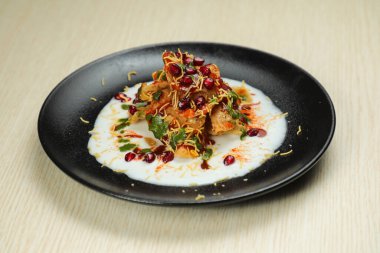 Doi Papri Chaat, papdi, bile bhalla, bhallay, patates, kraker, masala ve yoğurt arka planda izole edilmiş Hint baharatları sokak yemeklerinin üst görüntüsünde servis edilir.