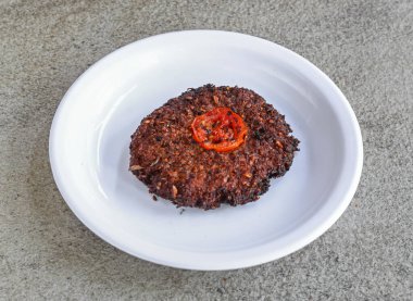 Gri arka planda Pakistan ve Hint baharatlarının üst görüntüsünde servis edilen kırmızı kebap.