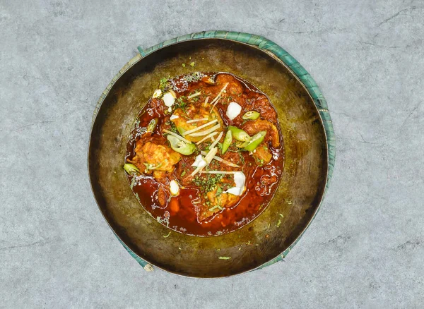 Arka planda Hint baharatları ve Pakistanlı yemeklerin üst görüntüsünde garvy ile servis edilen tavuk karahi korma masala.