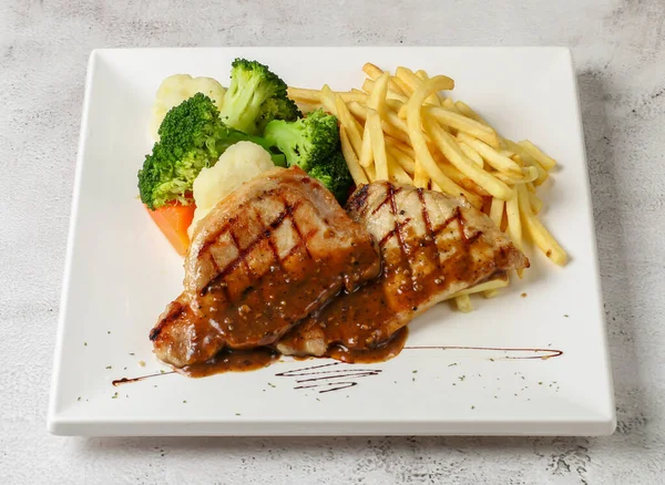 stock image spanish pork chops steak, french fries and salad served in dish isolated grey background top view singapore fast food