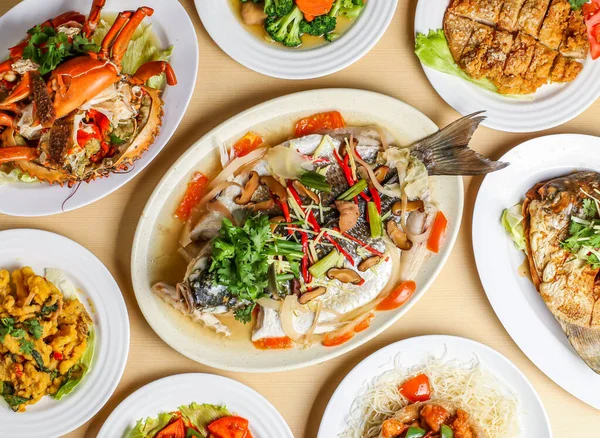 stock image steamed black mullet fish, steamed crab, stir fried broccoli wuth mushroom, fragrant fried chicken, salted egg squid, teochew pomfret, sweet sour and pork yamring top view singapore sea food variety