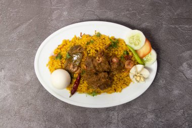 Biftek Bhuna Khichuri, biryani, pulao, haşlanmış yumurta ve salatayla servis edilen pirinç arka plandaki bangladeş yemeğinin üst görüntüsünde izole edilmiş.