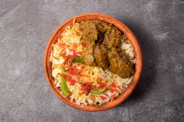 Hari Beef Biryani ya da yeşil et biryani pilavı, arka planda bangladeş yemeklerinin üst görüntüsünde izole edilmiş olarak servis edilir.