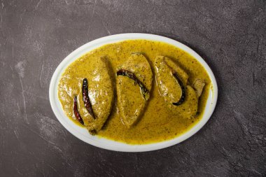 Arka planda izole edilmiş soslu balık körili korma masala Bangladeş yemeğinin üst görüntüsü