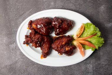 Tavuk Sıcak Kanatları arka planda izole bir şekilde servis edilir. Bangladeş yemeklerinin üst görüntüsü.