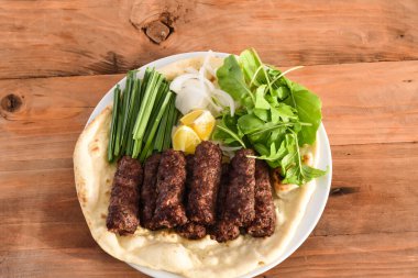 Swek Of Beef Kebab ya da Bahreyn ekmekli et kebabı tandır nan, limon ve salata ahşap masa üstü manzaralı, orta doğu ızgarasında servis edilir.